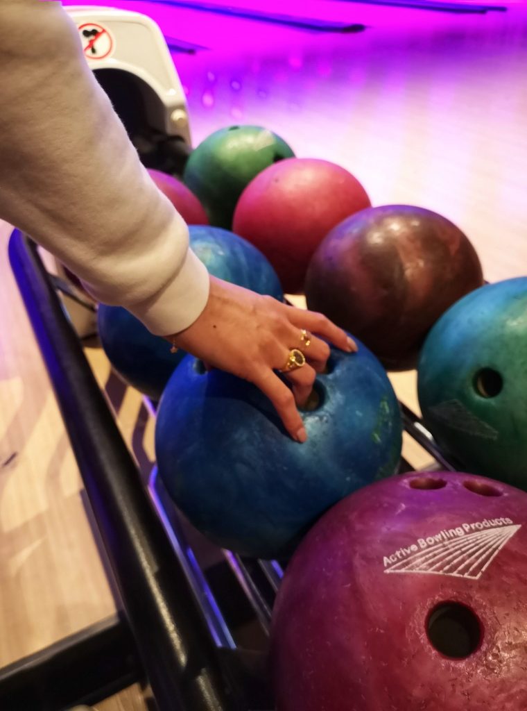 Grabbing a blue bowling ball to throw